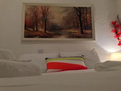 a white bed with a painting on the wall at Wilsons Hotel - Blackpool Tower View in Blackpool
