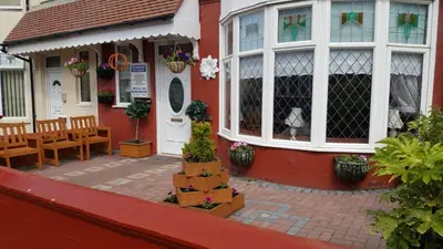 a red house with a table and chairs in front of it at The Kimberley B&B in Blackpool