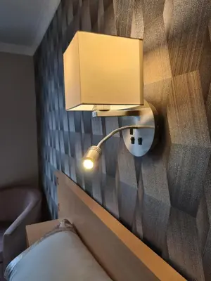 a lamp on a wall next to a bed at The Kimberley B&B in Blackpool