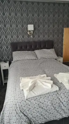 a bedroom with a bed with white towels on it at The Kimberley B&B in Blackpool