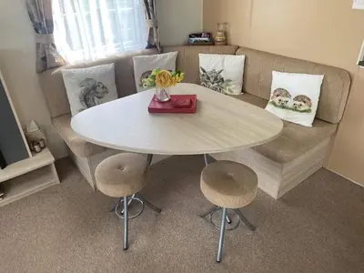 a table and chairs in a living room with a couch at Borwick Lakes Haven in Burton
