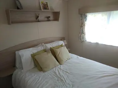 a bedroom with a white bed with two pillows at Borwick Lakes Haven in Burton