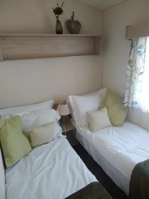 two beds sitting next to each other in a room at Borwick Lakes Haven in Burton