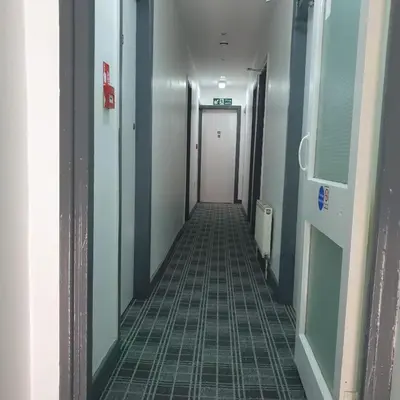 a hallway in a hospital with a door and a tile floor at Chilton Hotel in Blackpool
