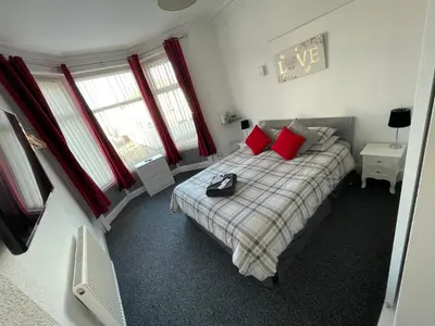 a bedroom with a bed with red pillows at Harleys Reads Avenue in Blackpool