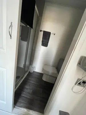 a bathroom with a toilet and a walk in shower at Harleys Reads Avenue in Blackpool