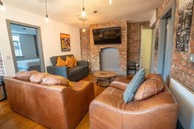 a living room with two leather couches and a fireplace at Urban Apartment Free Parking Near Pleasure Beach in Blackpool