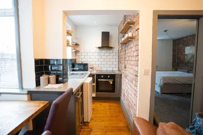 a small kitchen with a counter and a bedroom at Urban Apartment Free Parking Near Pleasure Beach in Blackpool