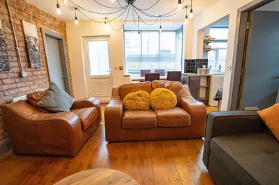 a living room with two leather chairs and a couch at Urban Apartment Free Parking Near Pleasure Beach in Blackpool