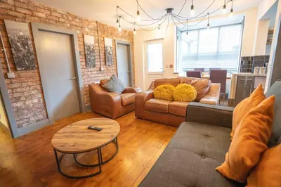 a living room with two couches and a table at Urban Apartment Free Parking Near Pleasure Beach in Blackpool