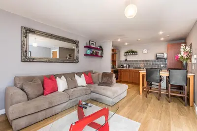a living room with a couch and a kitchen at Host & Stay - York Place Apt in Liverpool