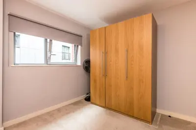 a large wooden cabinet in a room with a window at Host & Stay - York Place Apt in Liverpool