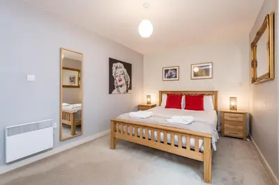 a bedroom with a large bed and a mirror at Host & Stay - York Place Apt in Liverpool