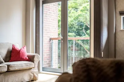a living room with a couch and a sliding glass door at Host & Stay - York Place Apt in Liverpool