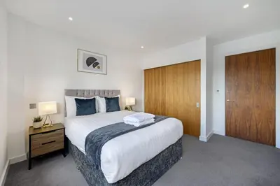 a bedroom with a large bed and a wooden door at Host & Stay - Waterfront View in Liverpool