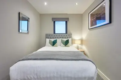 a bedroom with a large white bed with two windows at Host & Stay - Ropewalks Abode in Liverpool