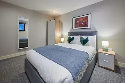 a bedroom with a large bed and two windows at Host & Stay - Ropewalks Abode in Liverpool