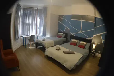 a hotel room with two beds and a window at Kensington Guest House Liverpool in Liverpool
