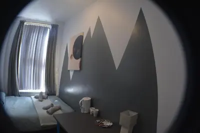 a bedroom with a bed and a table and a mirror at Kensington Guest House Liverpool in Liverpool