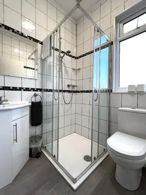 a bathroom with a shower and a toilet at Central Cove Guesthouse in Blackpool