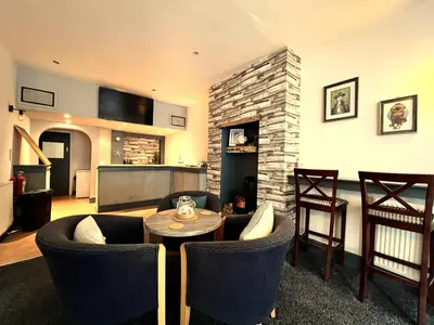 a living room with a table and chairs and a fireplace at Central Cove Guesthouse in Blackpool