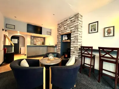 a living room with a table and chairs and a fireplace at Central Cove Guesthouse in Blackpool
