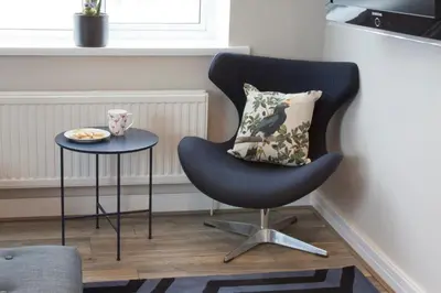 a black chair with a pillow and a table at Blackbird Luxury Apartments Room 4 in Blackpool