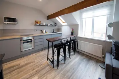 a kitchen with a table and some stools in it at Blackbird Luxury Apartments Room 4 in Blackpool