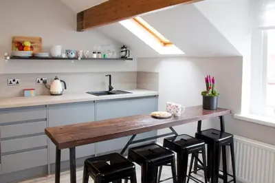 a kitchen with a wooden table and black stools at Blackbird Luxury Apartments Room 4 in Blackpool