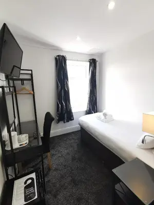 a small room with a bed and a window at The Kerswell Hotel Sea Front in Morecambe