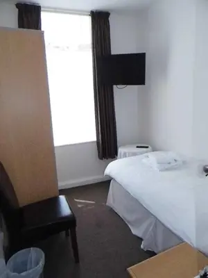 a bedroom with a white bed and a window at The Kerswell Hotel Sea Front in Morecambe