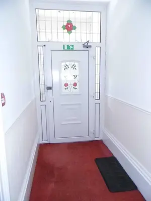 a white door with a window and a red carpet at The Kerswell Hotel Sea Front in Morecambe