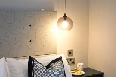 a bedroom with a bed with a table and a lamp at Blackbird Luxury Apartments Room 3 in Blackpool