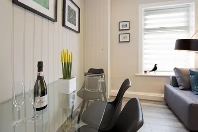 a living room with a glass table and a bottle of wine at Blackbird Luxury Apartments Room 2 in Blackpool