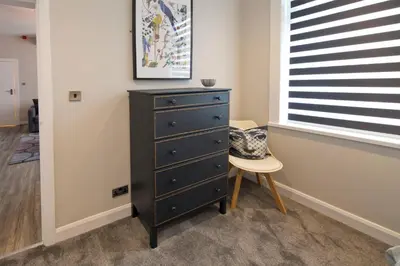 a black dresser and a chair in a room at Blackbird Luxury Apartments Room 1 in Blackpool