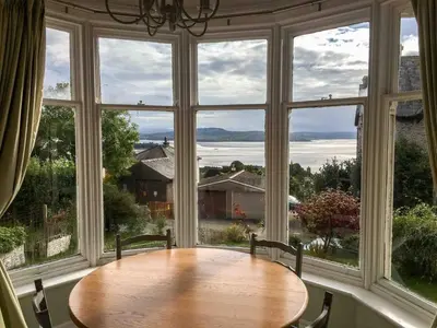 a table in a room with a large window at East Bank Apartment in Grange Over Sands