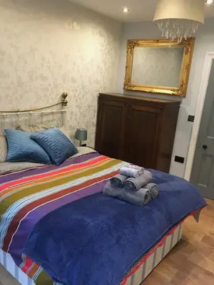 a bedroom with a bed with towels on it at East Bank Apartment in Grange Over Sands