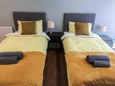 two beds sitting next to each other in a room at East Bank Apartment in Grange Over Sands