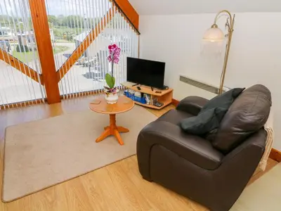 a living room with a leather couch and a table at Shorefields One in Morecambe