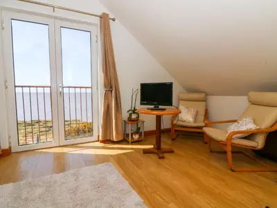 a living room with a large window and a television at Shorefields One in Morecambe