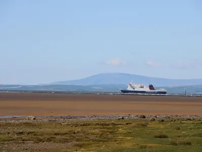 a large ship on the water with mountains in the background at Shorefields One in Morecambe