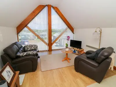 a living room with two leather couches and a tv at Shorefields One in Morecambe