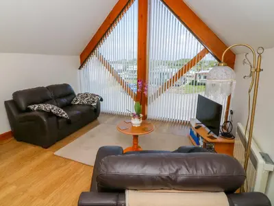 a living room with a leather couch and a television at Shorefields One in Morecambe