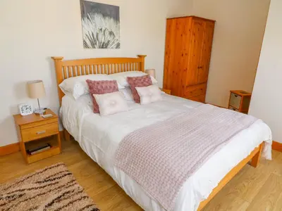 a bedroom with a bed with a wooden headboard at Shorefields Two in Morecambe