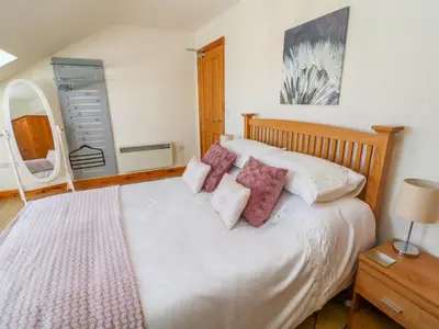 a bedroom with a large white bed with pink pillows at Shorefields Two in Morecambe