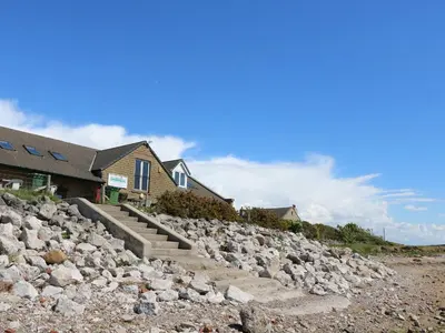 a house with a bunch of rocks next to a house at Shorefields Two in Morecambe