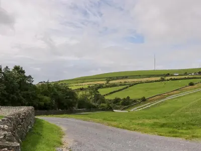 a road in the middle of a green field at Oak Lodge in Ulverston