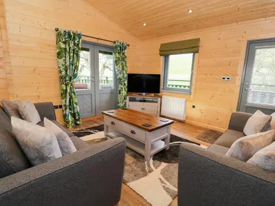 a living room with two couches and a tv at Oak Lodge in Ulverston