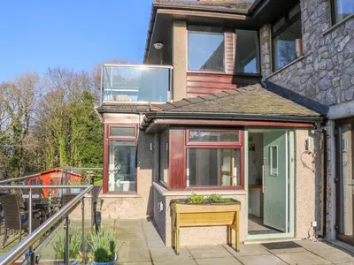 a house with a porch with a desk in front of it at Shady Bowers in Carnforth