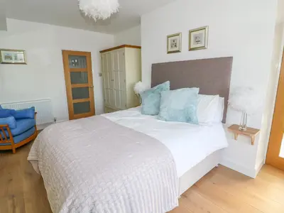 a bedroom with a bed and a blue chair at Shady Bowers in Carnforth